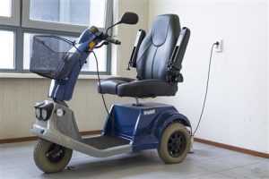 Home Een persoon rijdt veilig met een scootmobiel door de stad op het trottoir, attent op voetgangers en verkeer.